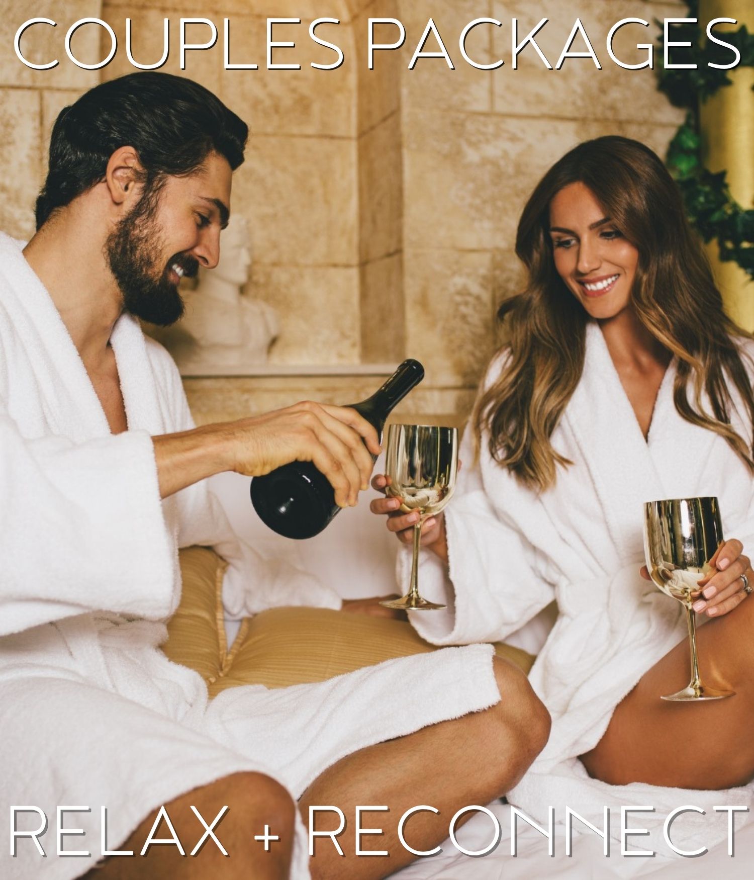 a sweet couple wearing a bathrobe sitting at their bed and having a toast promoting couple packages with relax + reconnect